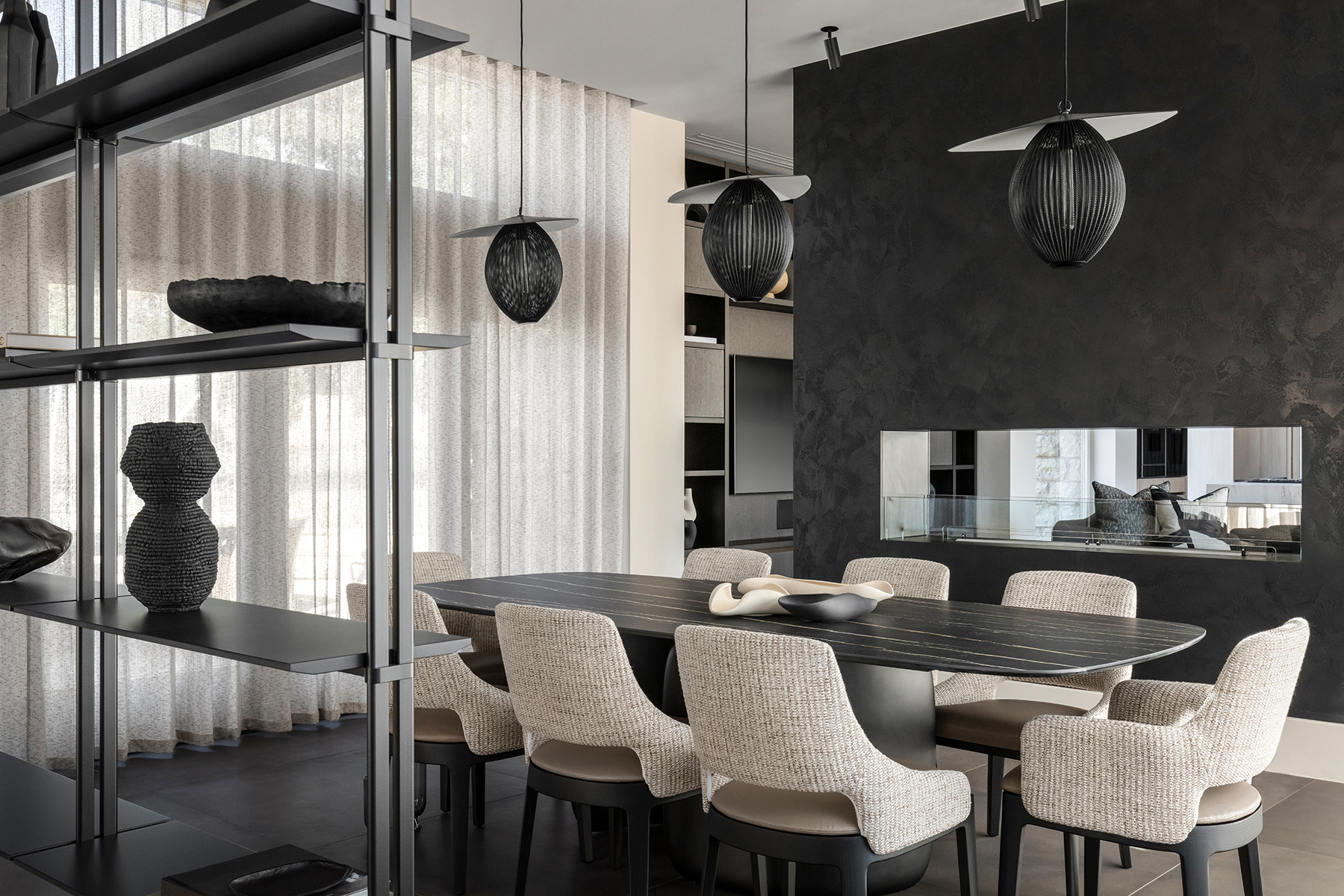 Expansive modern dining space with a rectangular dining table, linen upholstered chairs and a view of a sleek fireplace.